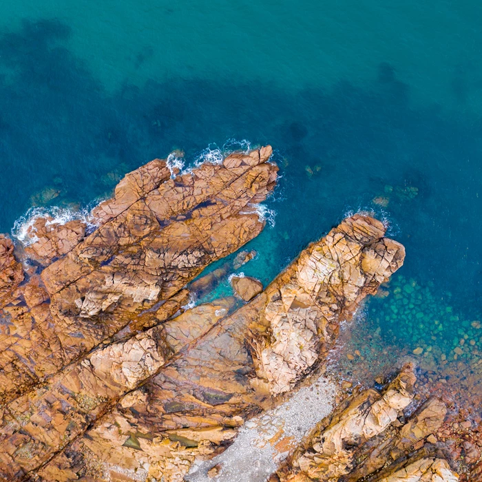 Colour photo of rocks and sea, top down aerial photography