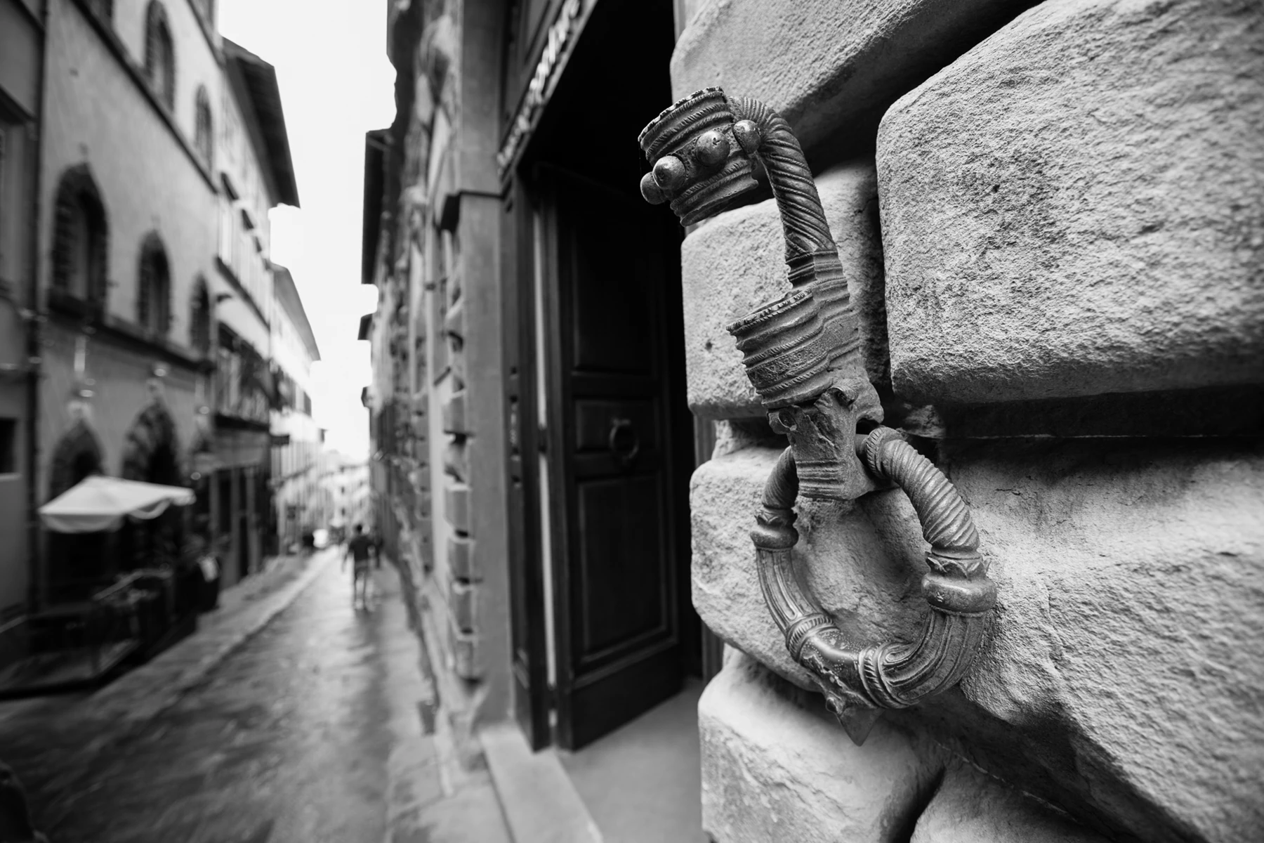 Black & white photo of a stone statue on a wall