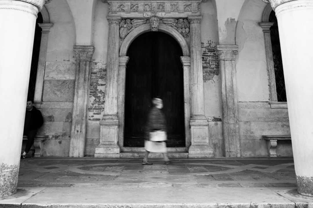 Black & white photo of a person standing in a doorway