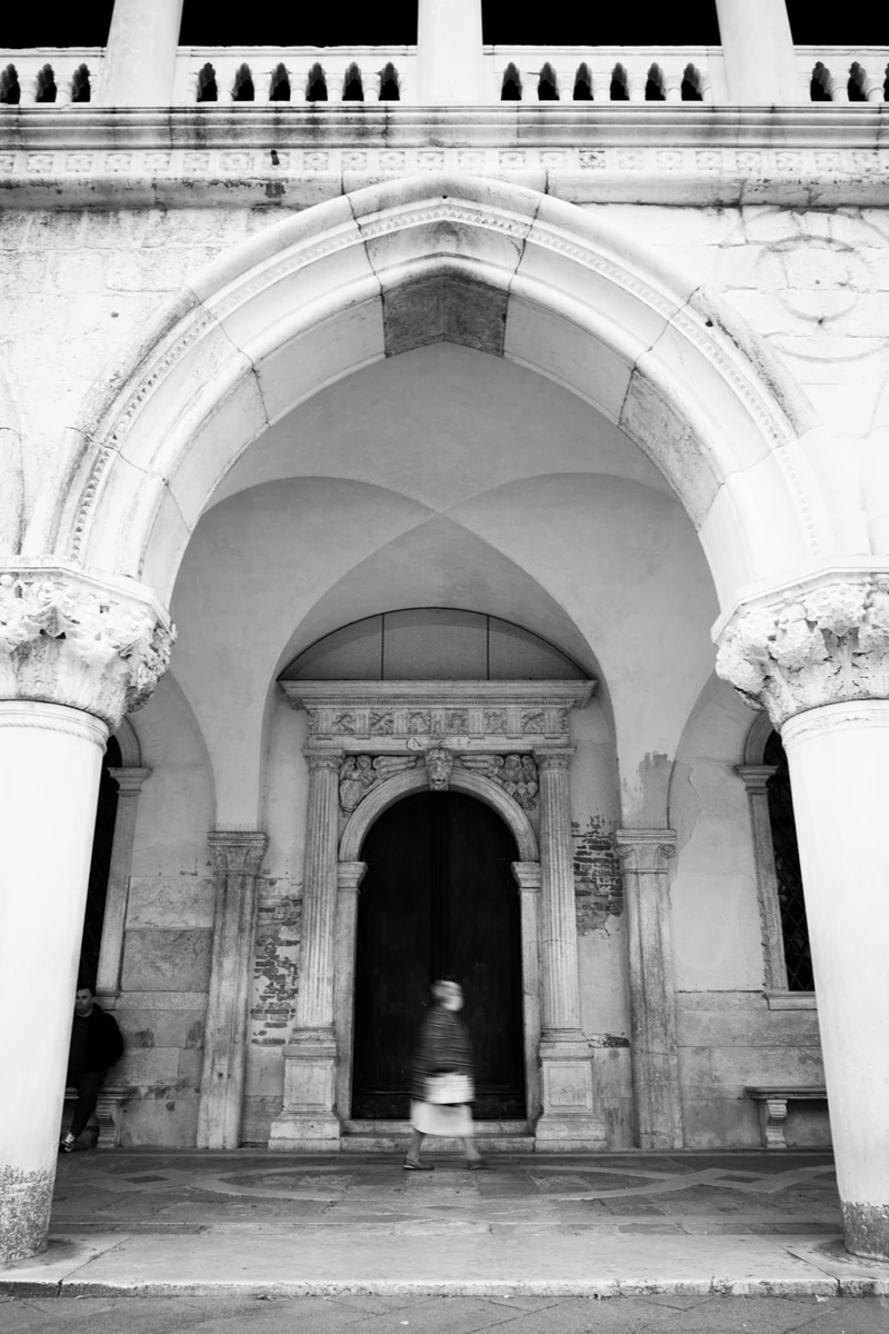Black & white photo of a person standing in a doorway
