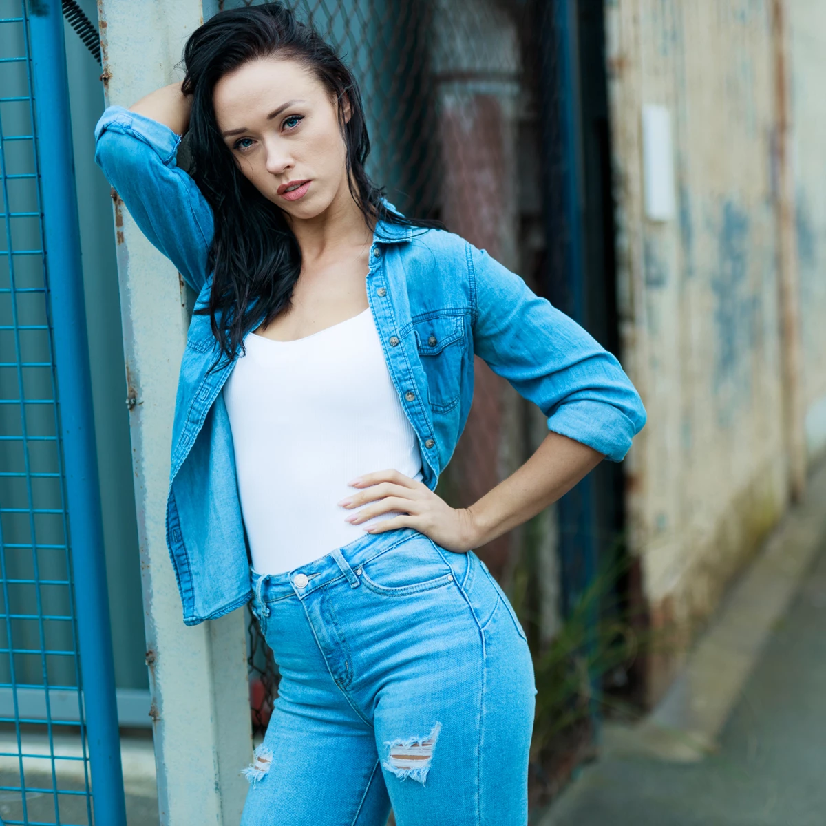 Lifestyle photo of woman standing in front of wire fencing