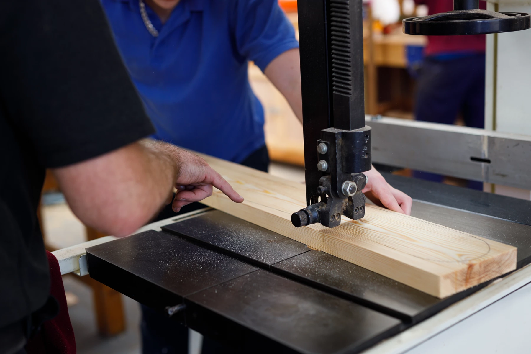 Colour photo of a person cutting a wood