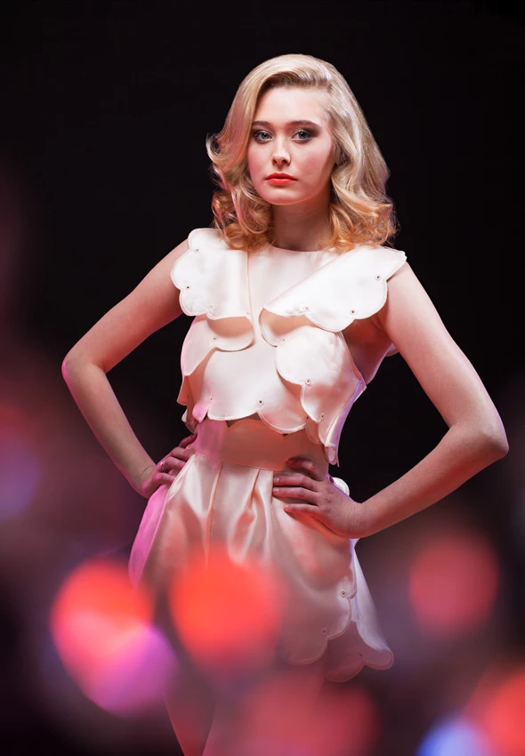 Studio fashion photo of woman with twinkly lights in foreground