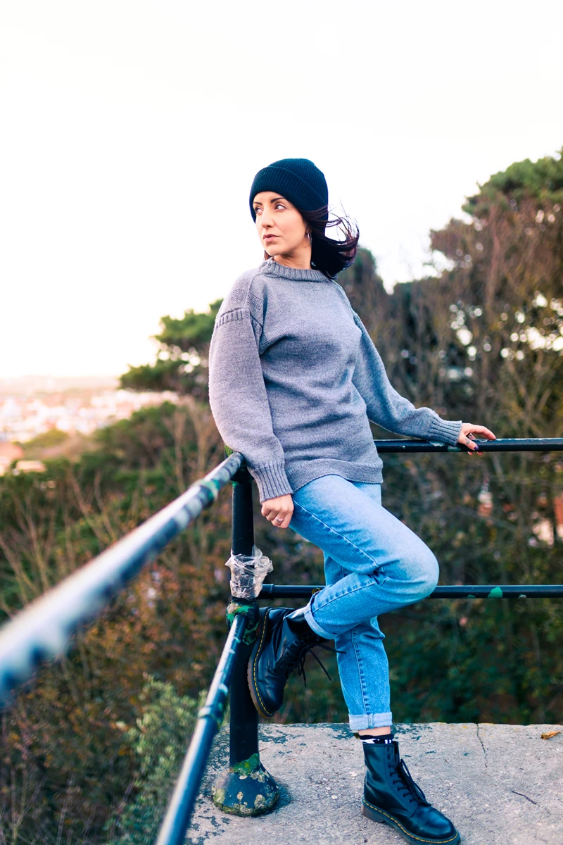 Colour photo of a man sitting on a railing