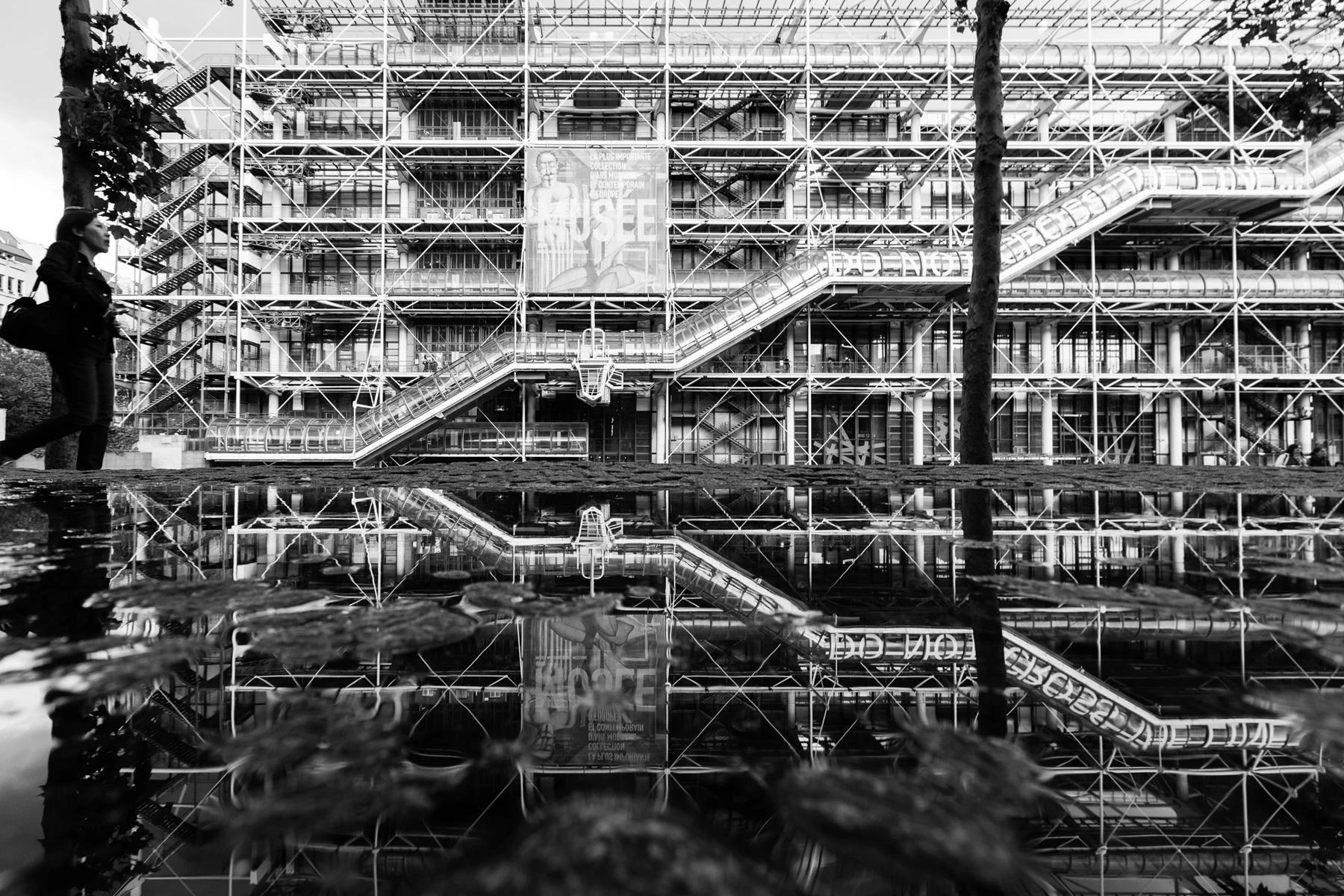 Black & white photo of a person standing on a bridge