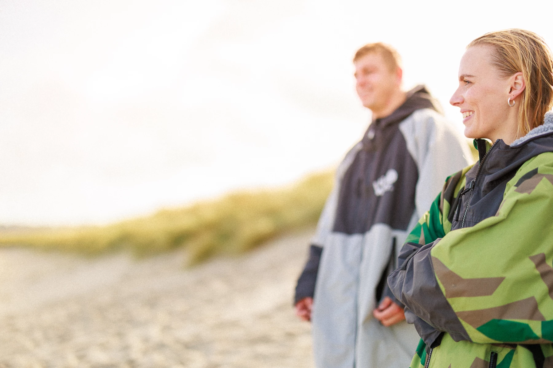 Colour photo of a man and woman walking on a beach