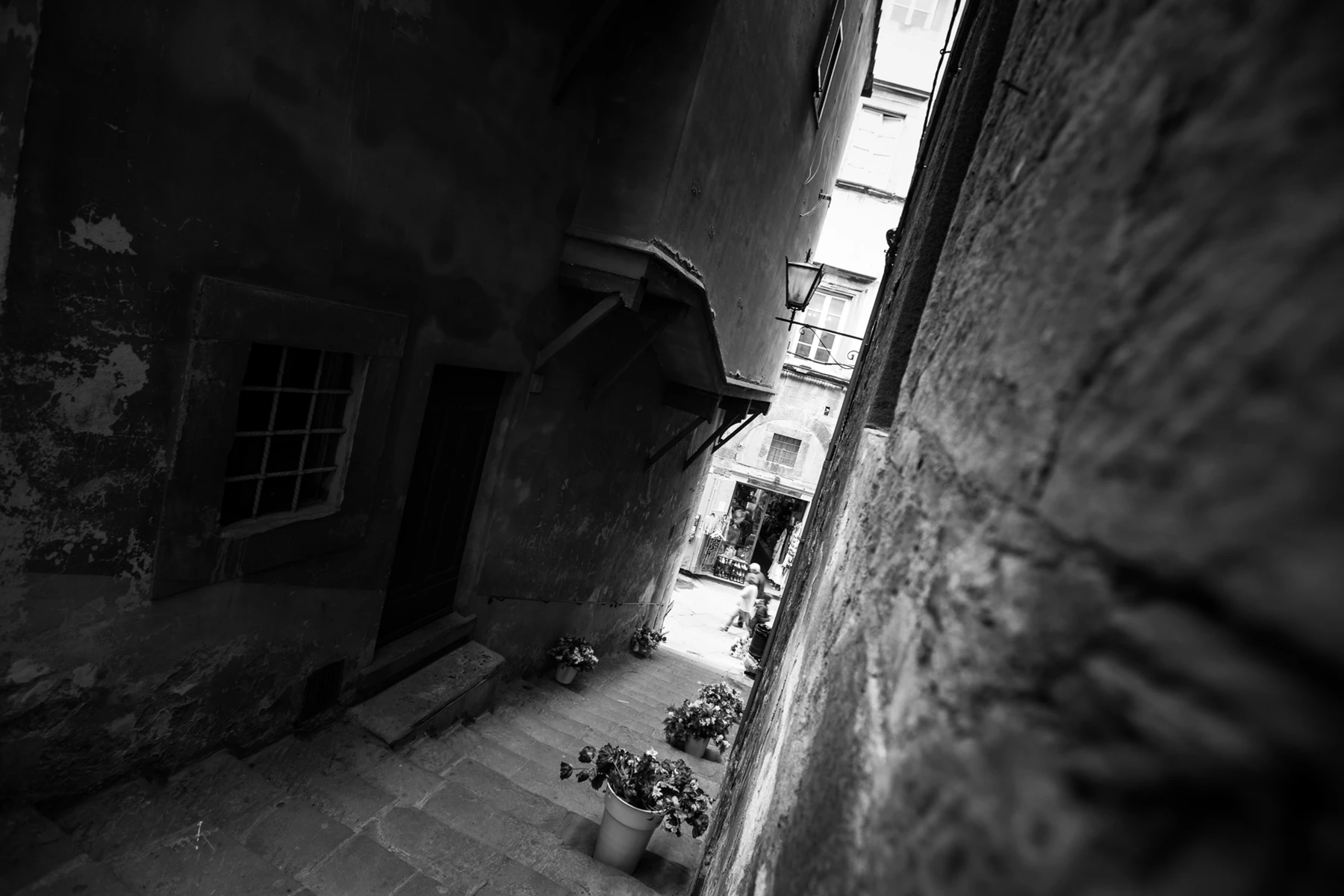 Black & white photo of a stone alleyway with a window