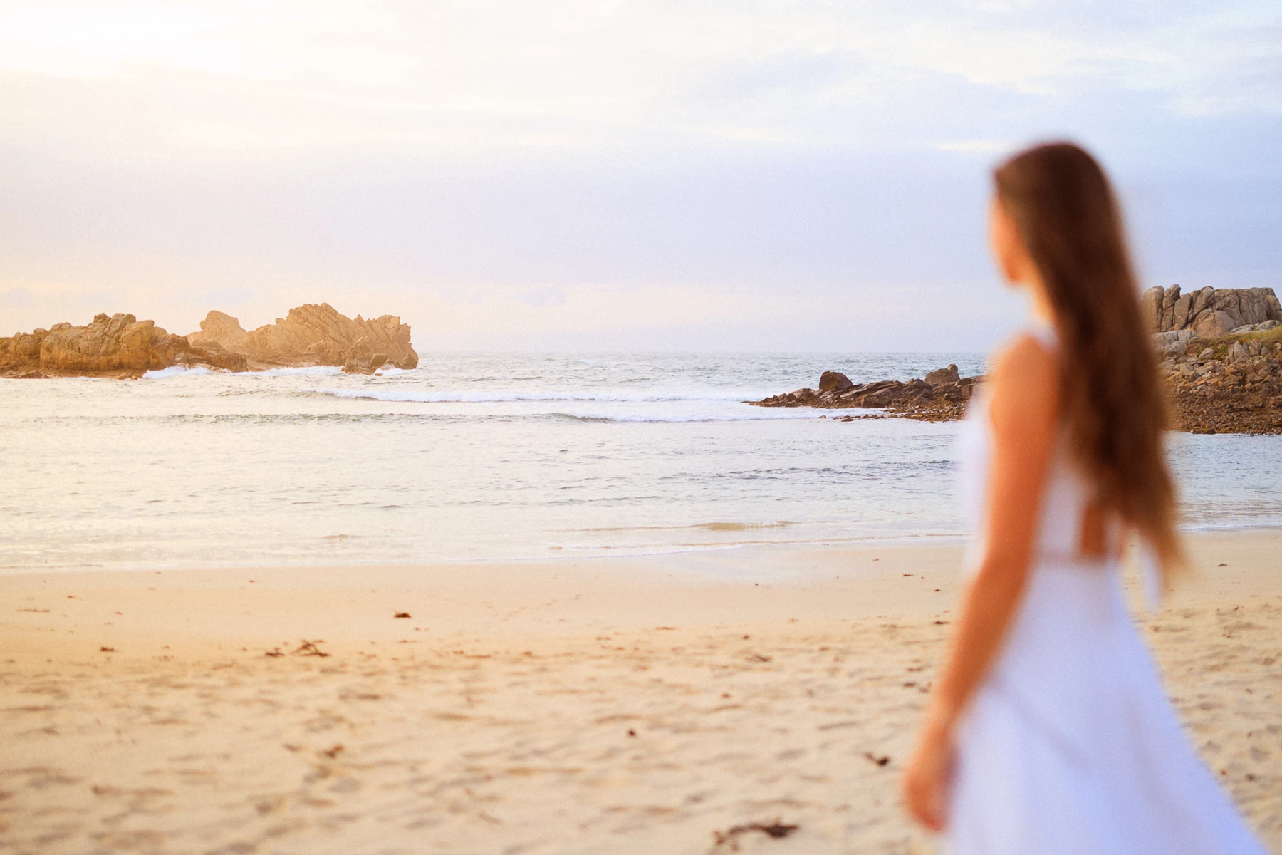 Colour photo of a person standing on a beach