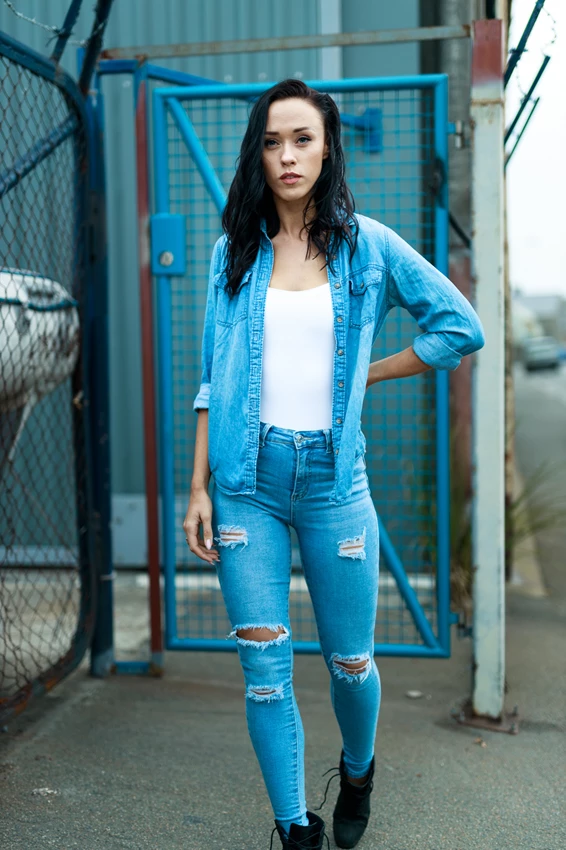 Lifestyle photo of woman standing in front of wire fencing