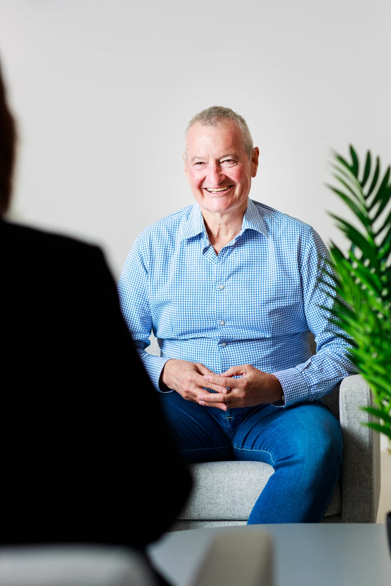 Colour photo of a man sitting on a couch