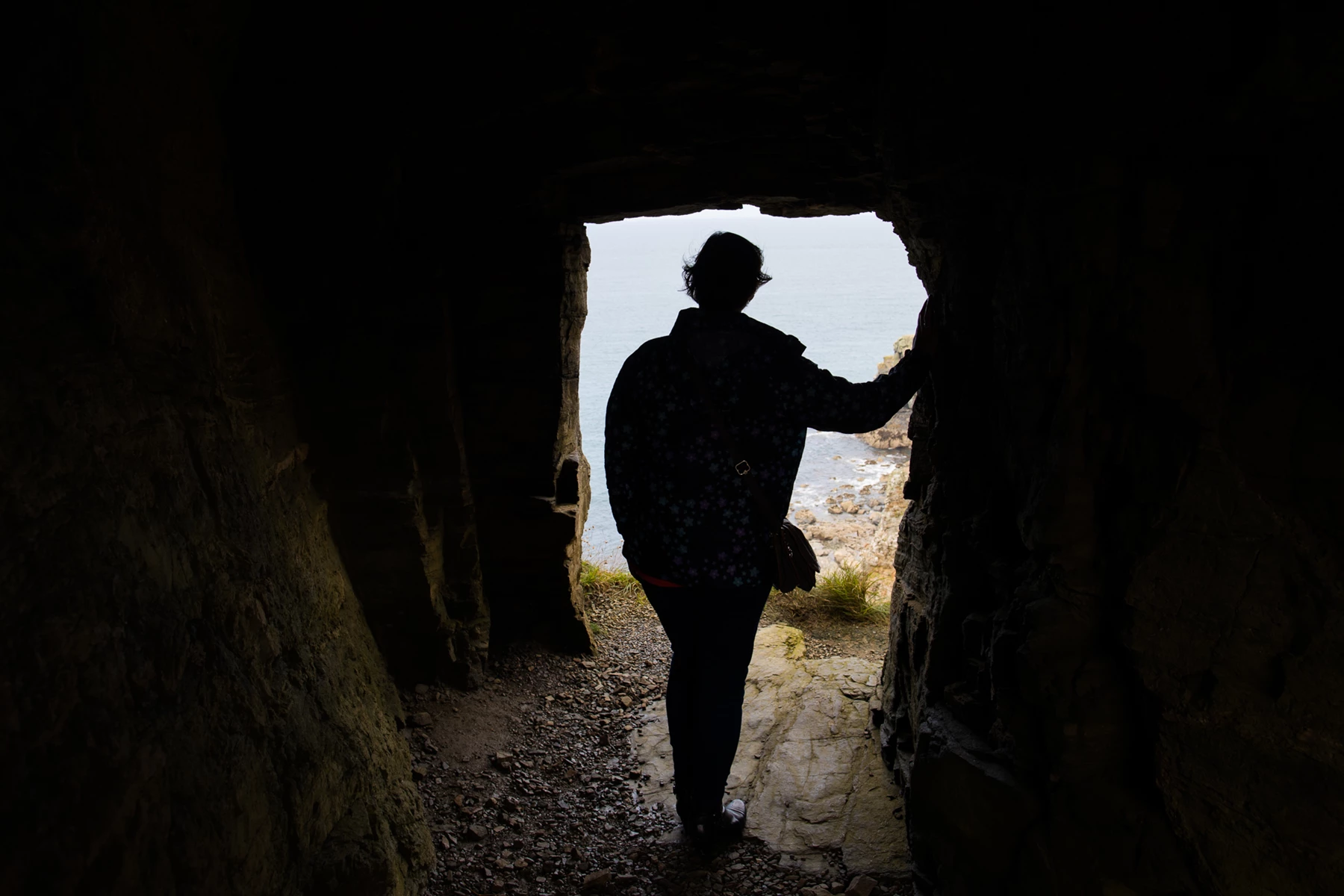 Colour photo of a person standing in a cave