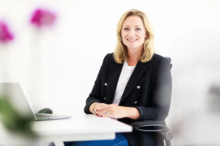 Colour photo of a woman sitting at a table
