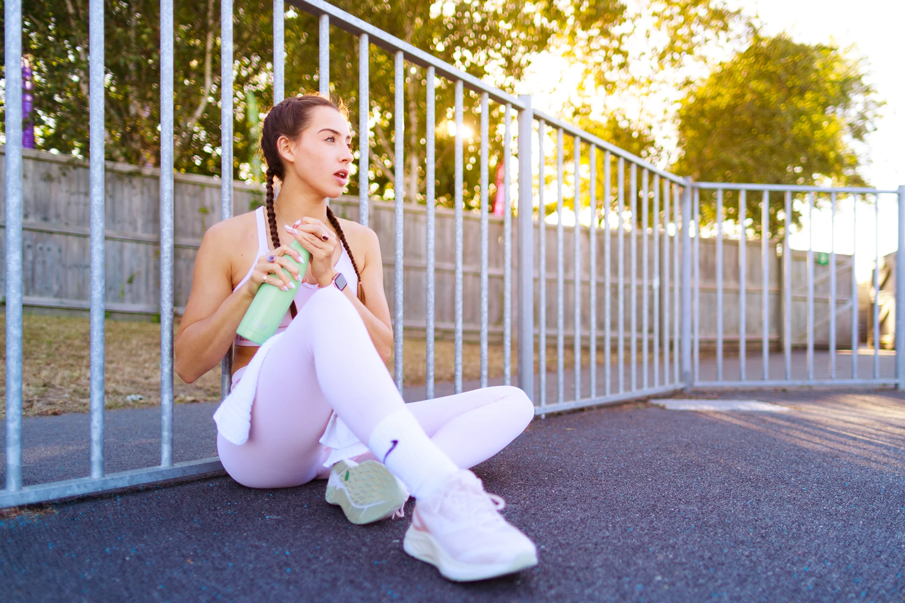 Colour photo of a woman sitting on a sidewalk