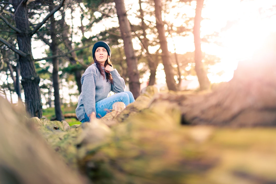 Colour photo of a man sitting in a forest