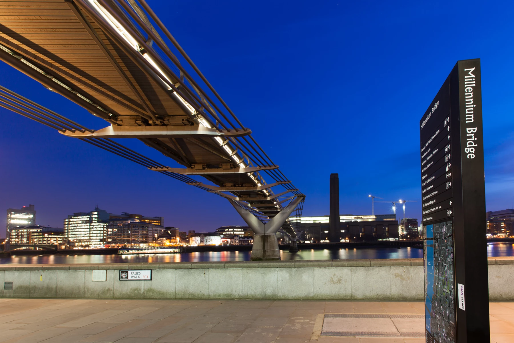 Colour photo of a bridge with a city in the background