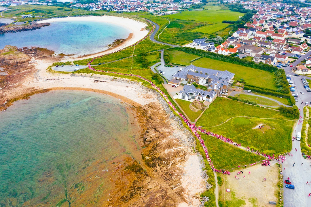 Colour photo of a beach with houses and water
