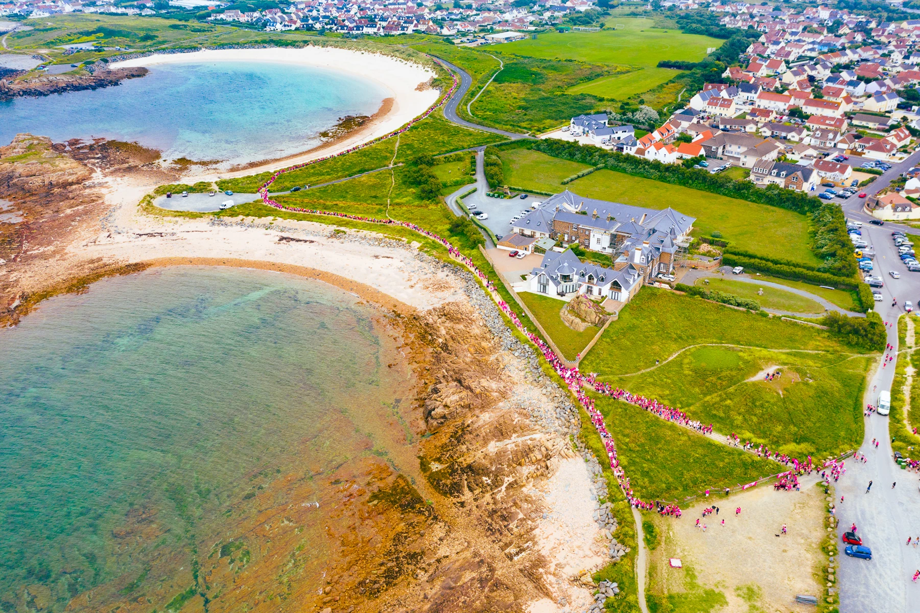 Colour photo of a beach with houses and water
