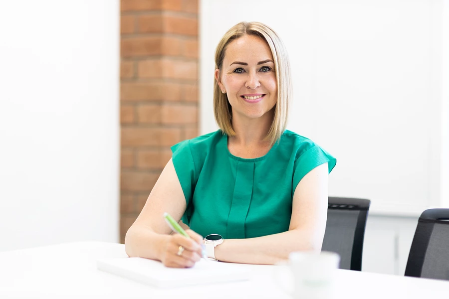 Colour photo of a woman sitting at a table