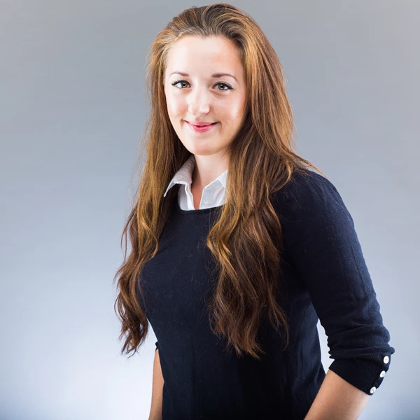 Business portrait of young woman against grey background