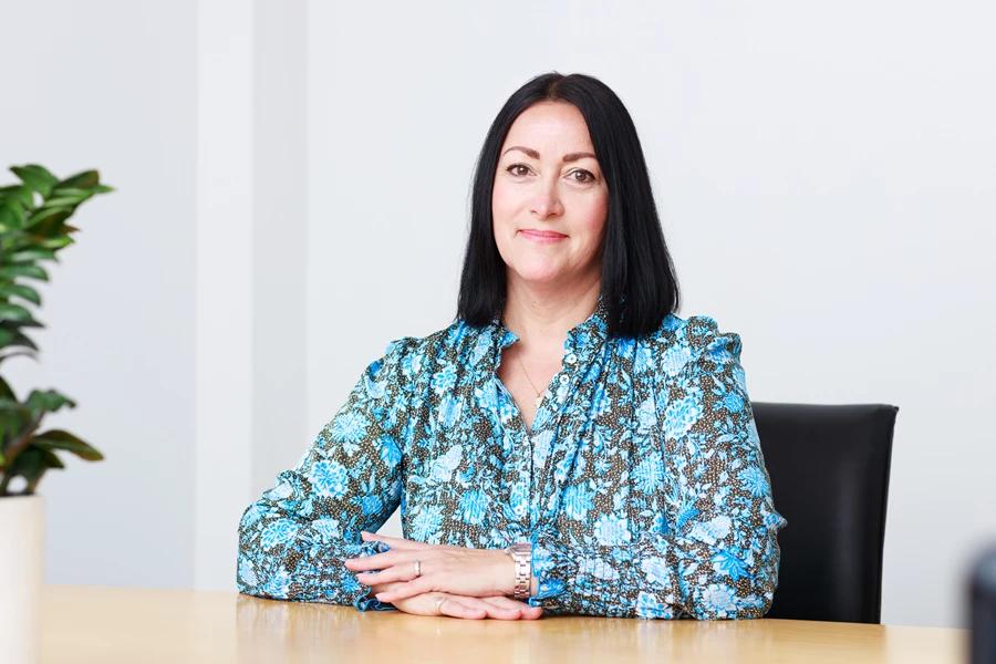 Colour photo of a woman sitting at a table