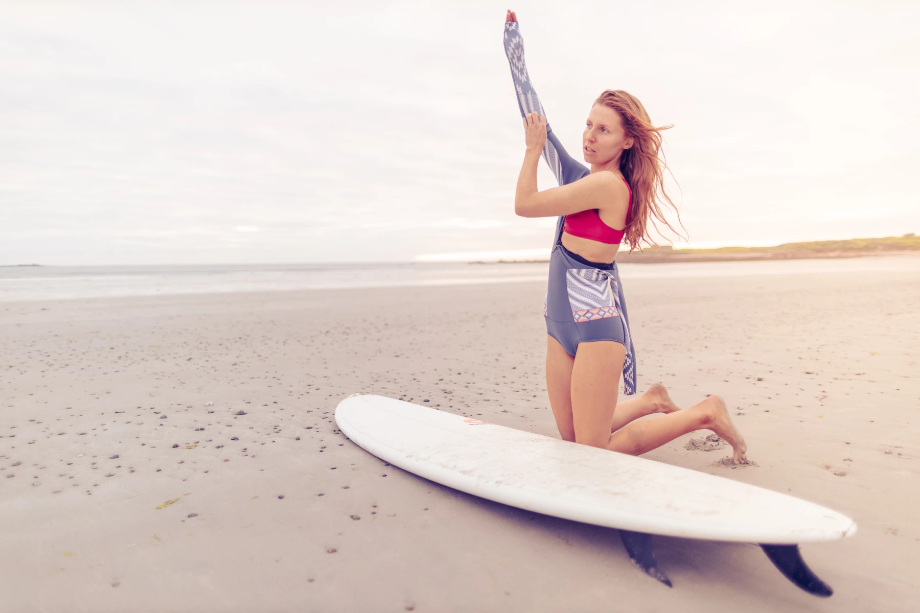 Colour photo of a woman in a swimsuit on a surfboard