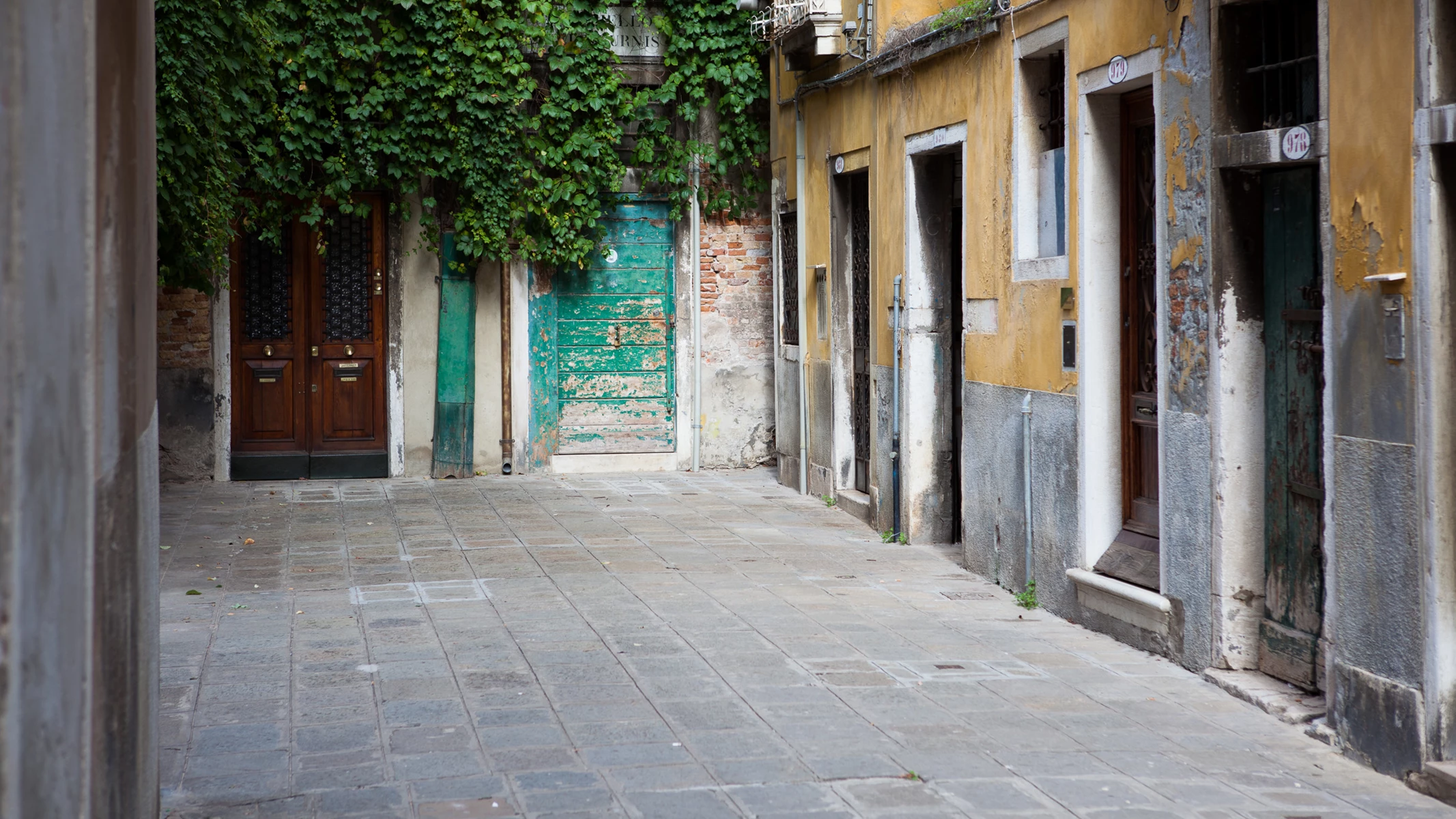Colour photo of a stone walkway between two buildings