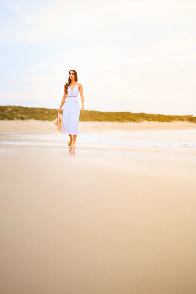 Colour photo of a person walking on a beach