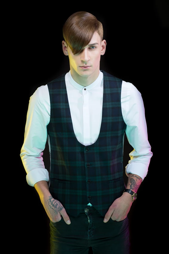 Stylish portrait of man with tatoos with coloured gel lighting against black background
