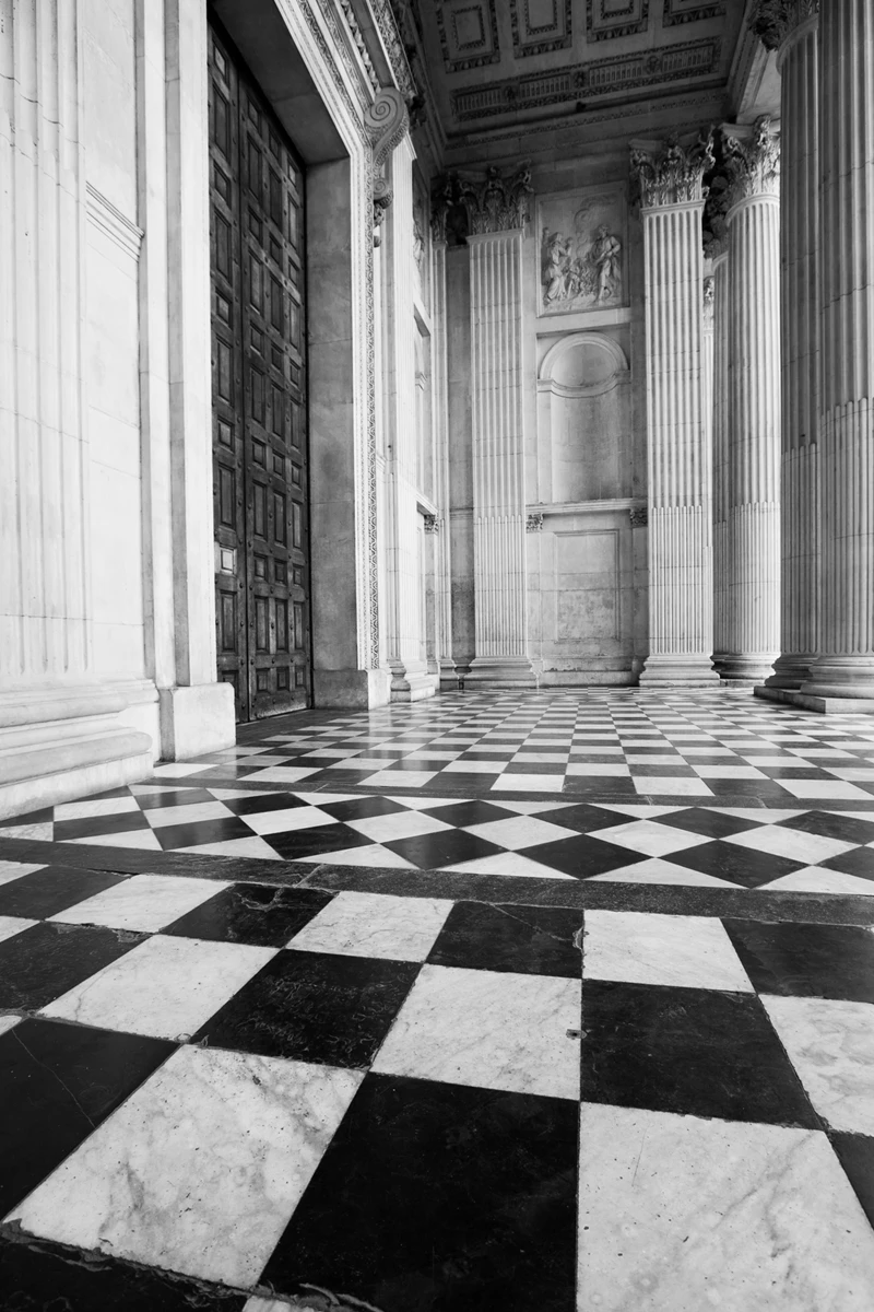 Black and white photo of a hallway with pillars
