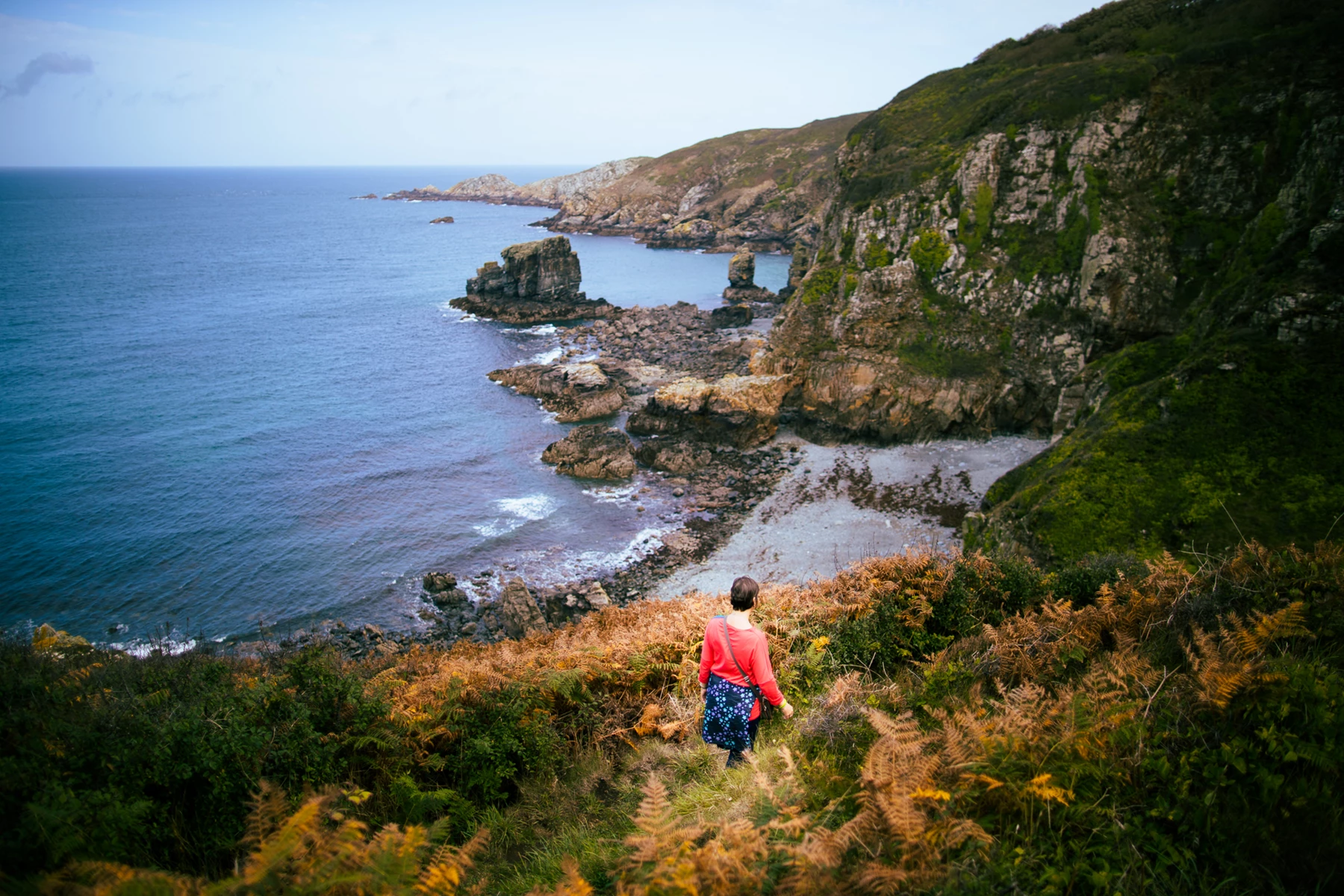 Colour photo of a woman walking on a path by a body of water