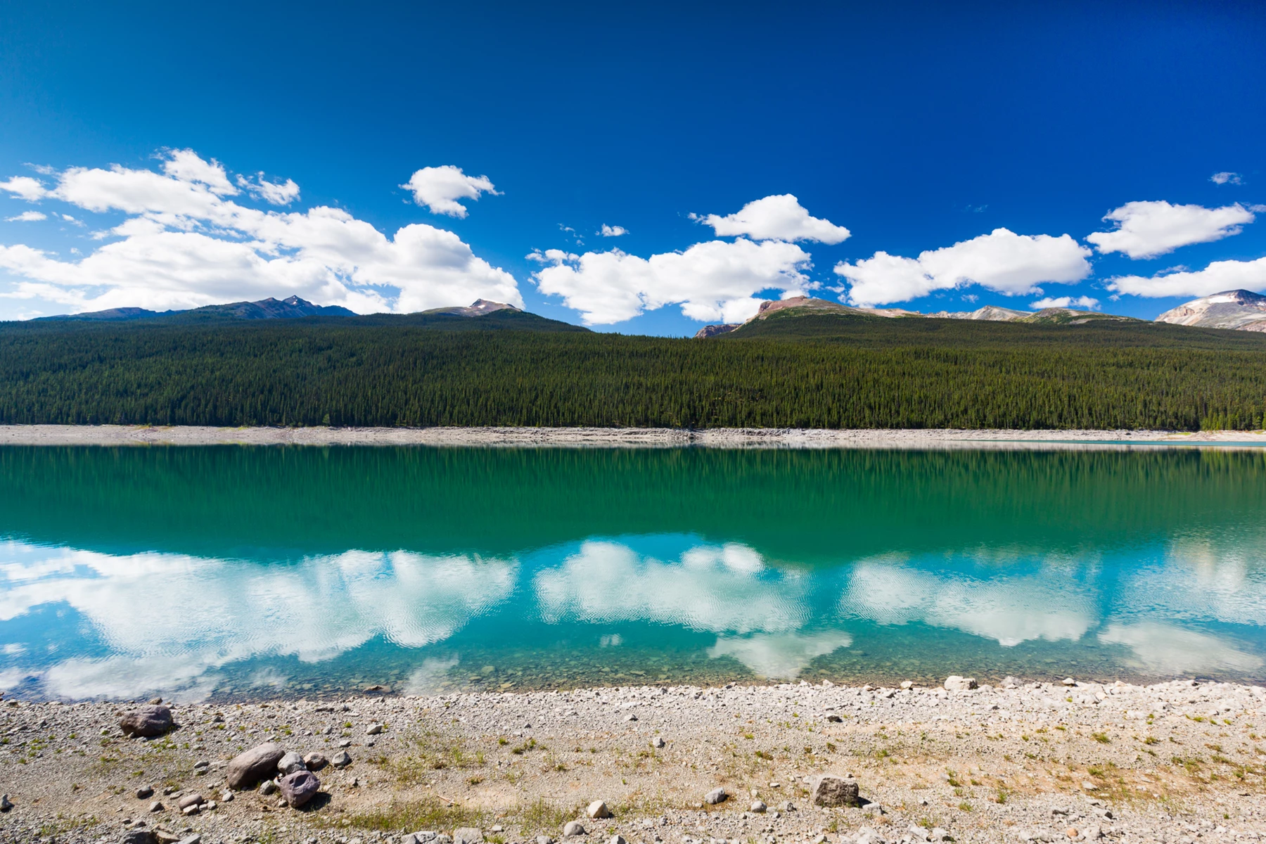 Colour photo of a body of water with a hill in the background