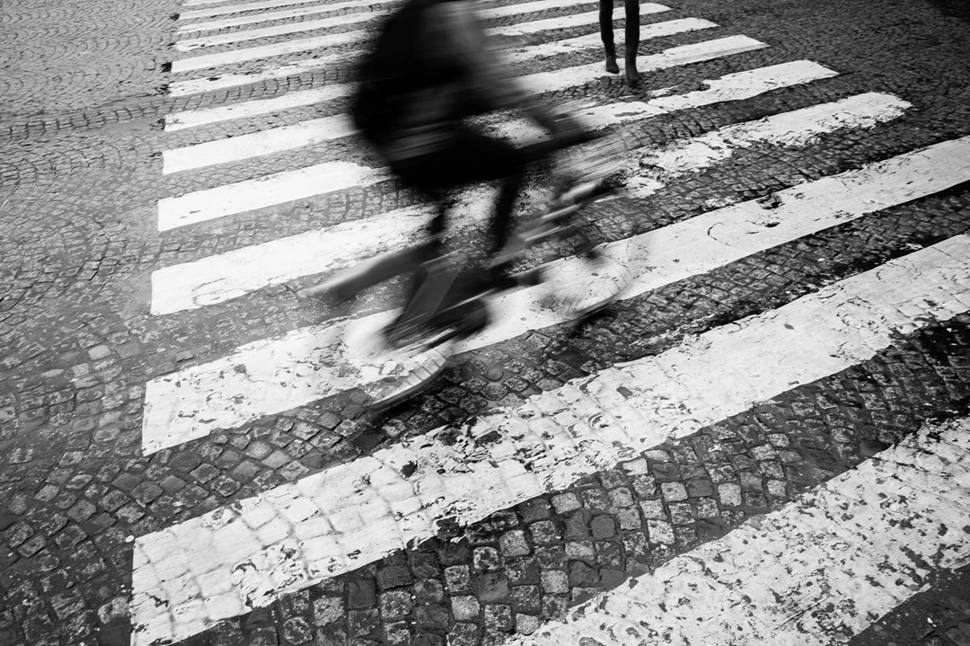 Black & white photo of a person crossing a street
