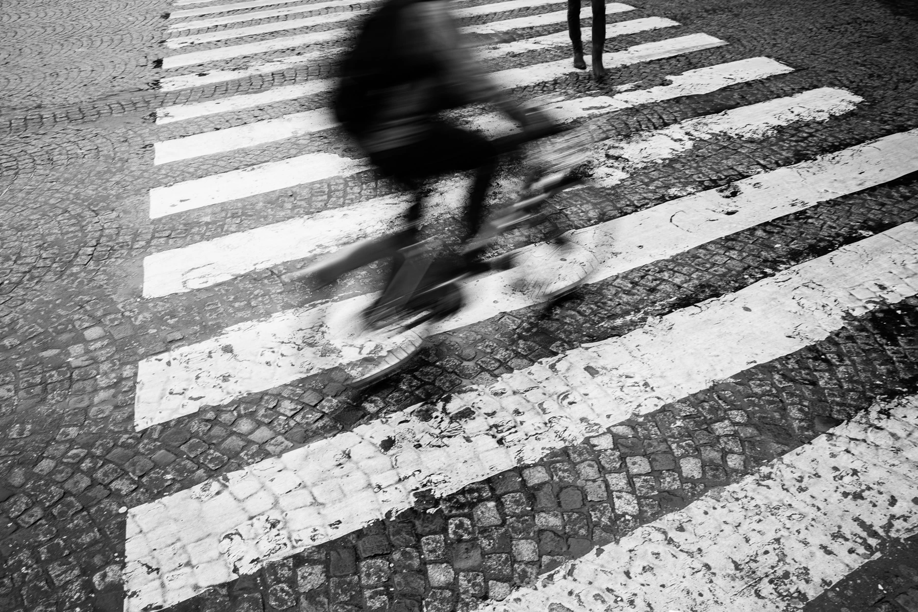 Black & white photo of a person crossing a street