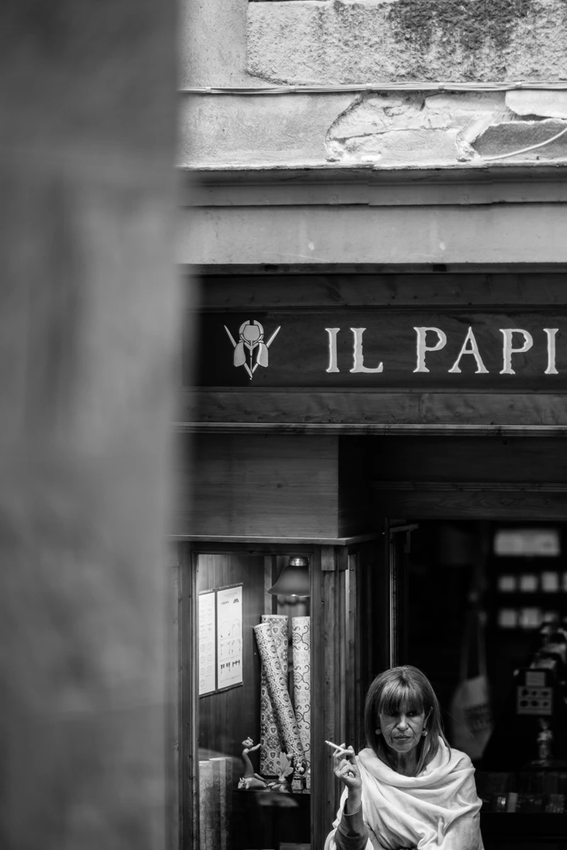 Black & white photo of a person standing in front of a store