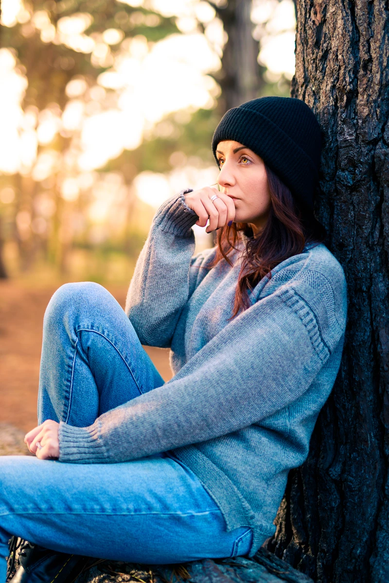 Colour photo of a person sitting on a tree