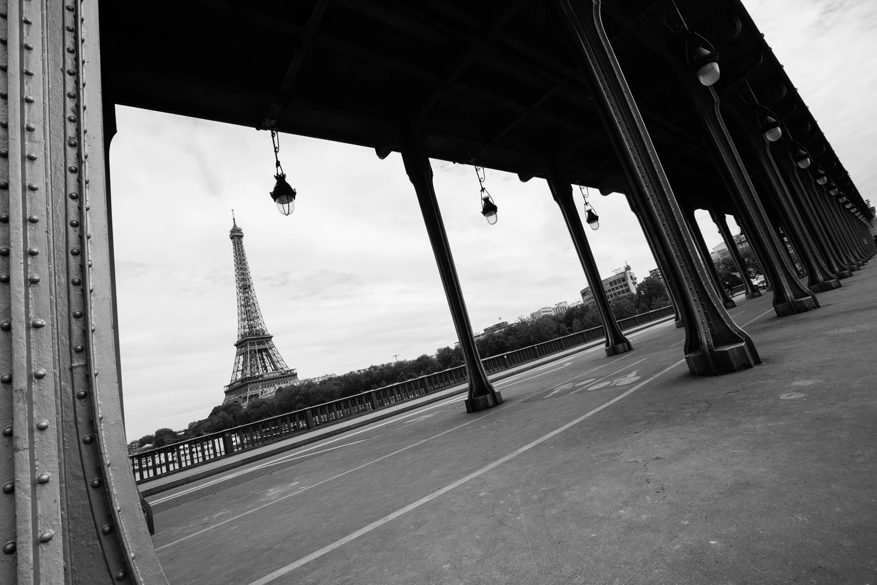 Black & white photo of a road with a tower in the distance