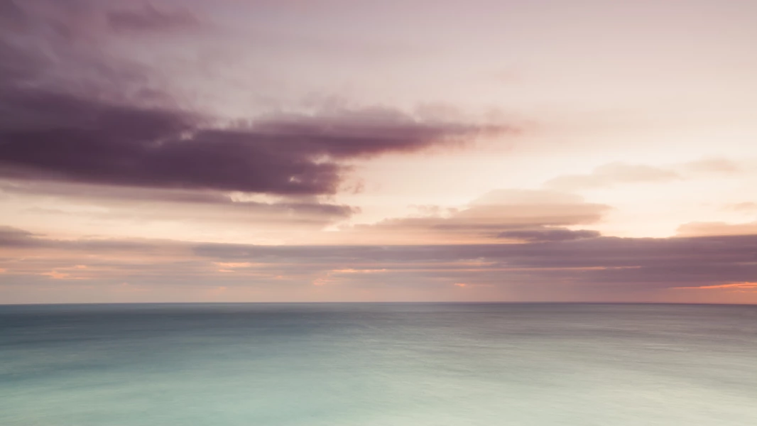 Dreamy style landscape photo of sea with sunset sky colours