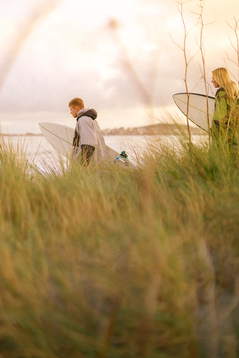 Colour photo of a man and woman walking on a beach