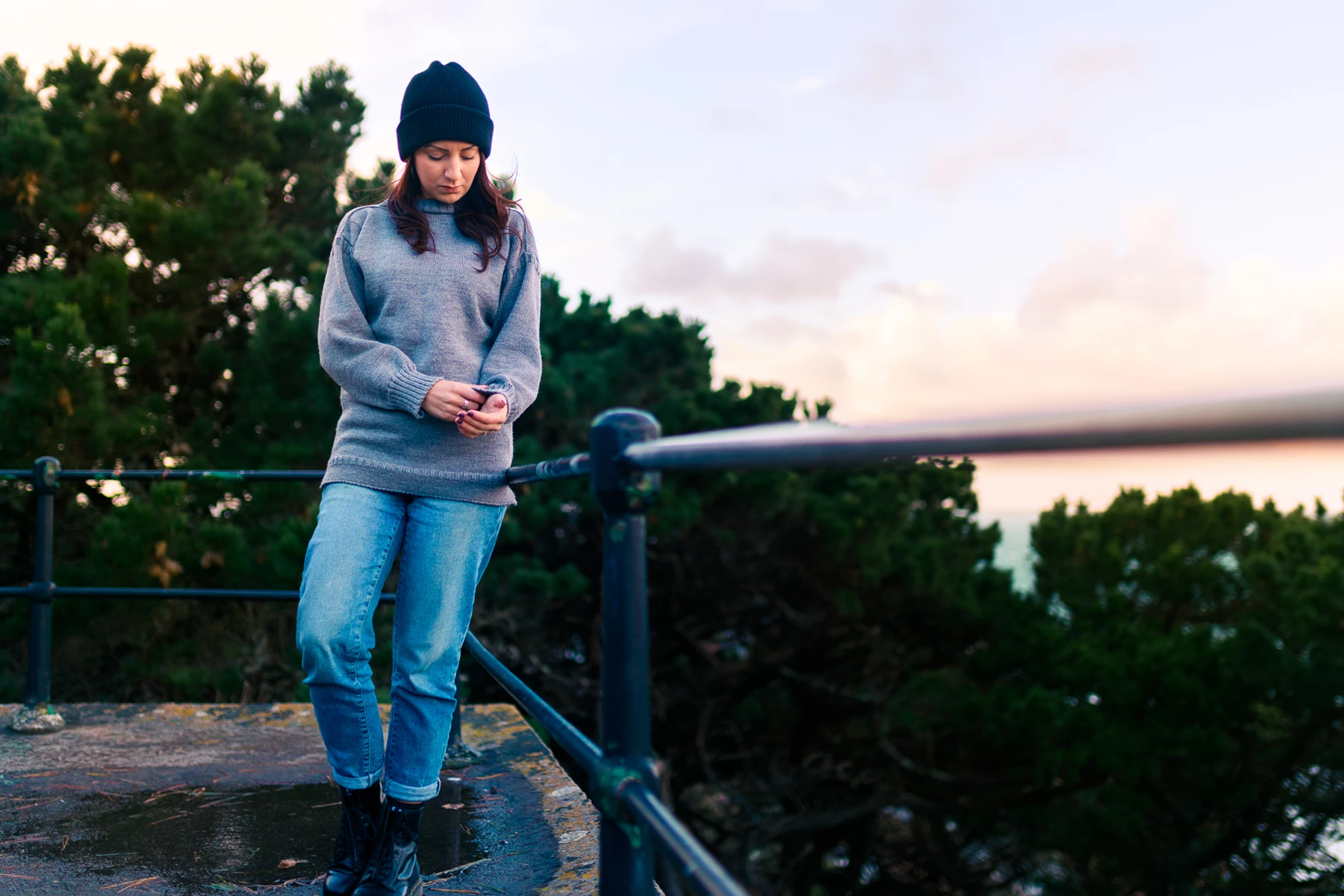 Colour photo of a person standing on a railing