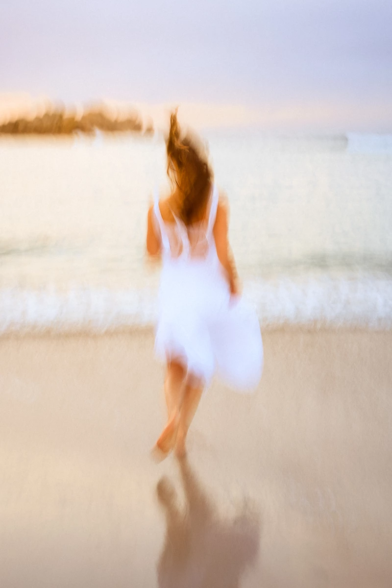 Colour photo of a person walking on a beach
