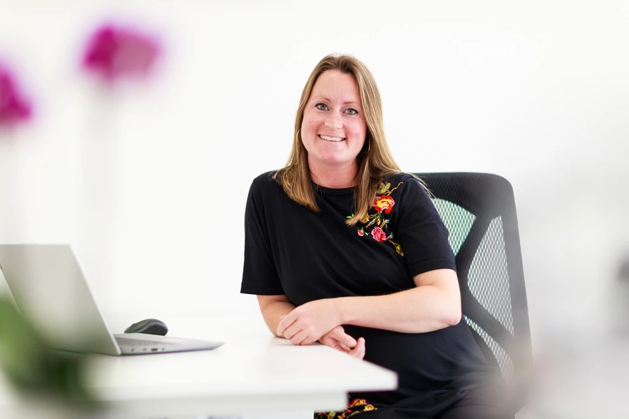 Colour photo of a woman sitting at a table