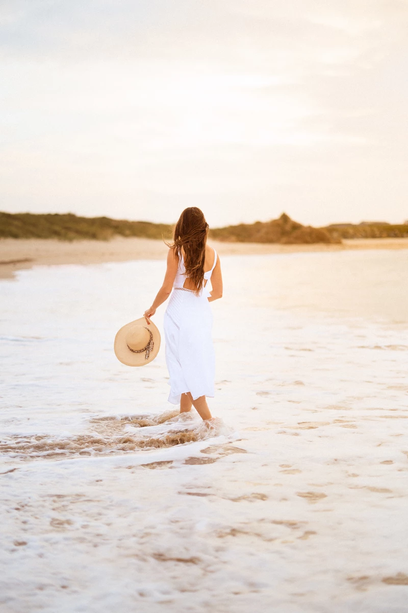 Colour photo of a person walking on a beach