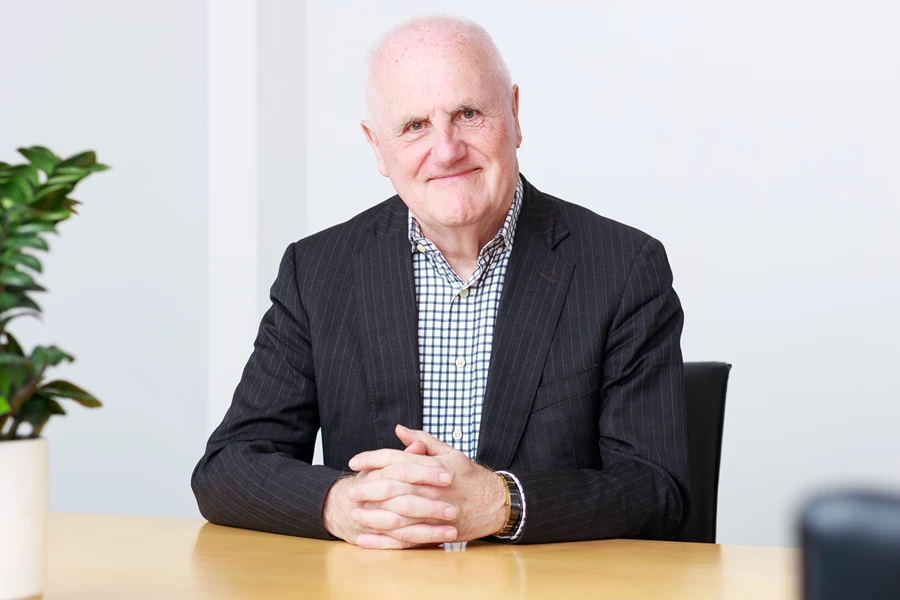 Colour photo of a man sitting at a table