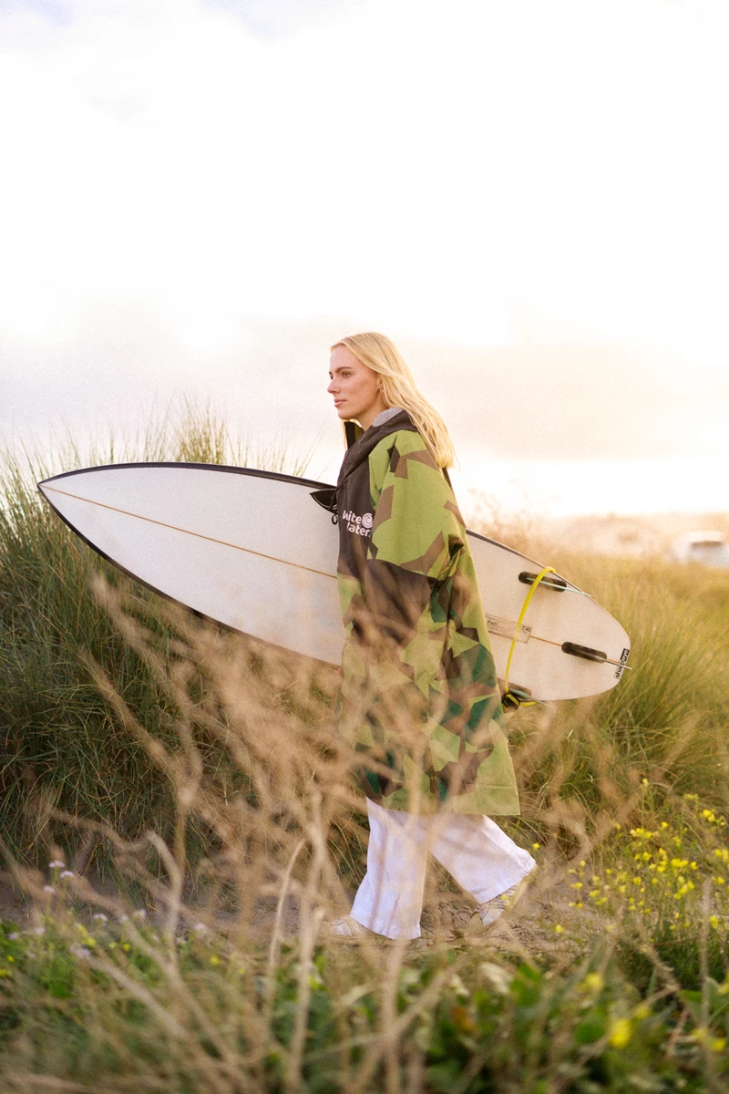 Colour photo of a person holding a surfboard
