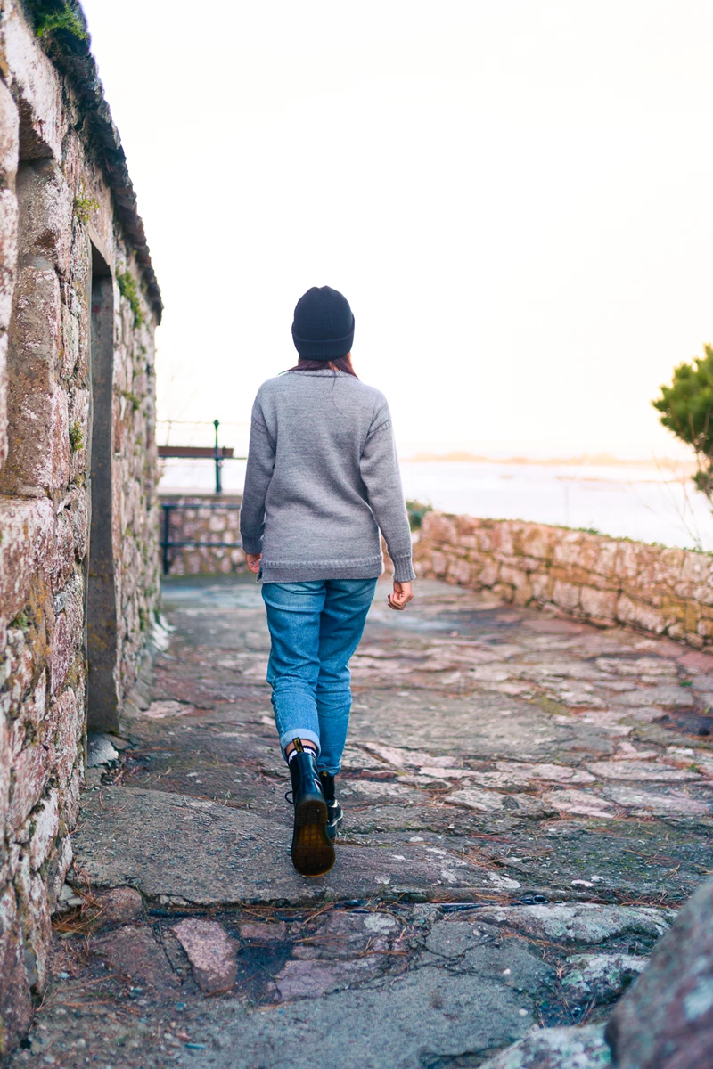 Colour photo of a person walking on a stone path