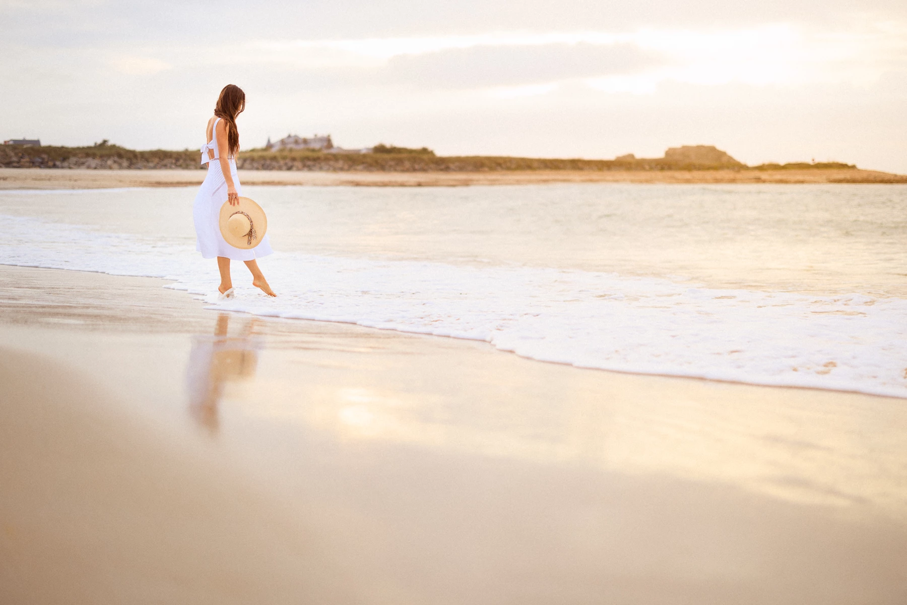 Colour photo of a person walking on a beach