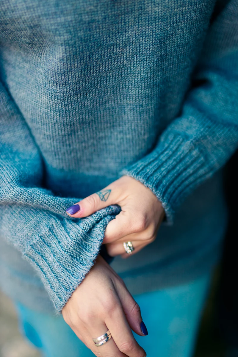 Colour photo of a woman's hands with rings on her fingers