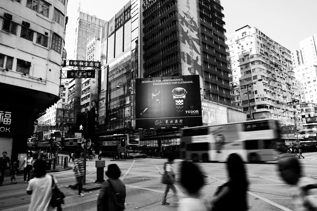 Black & white photo of a city street with people and a bus