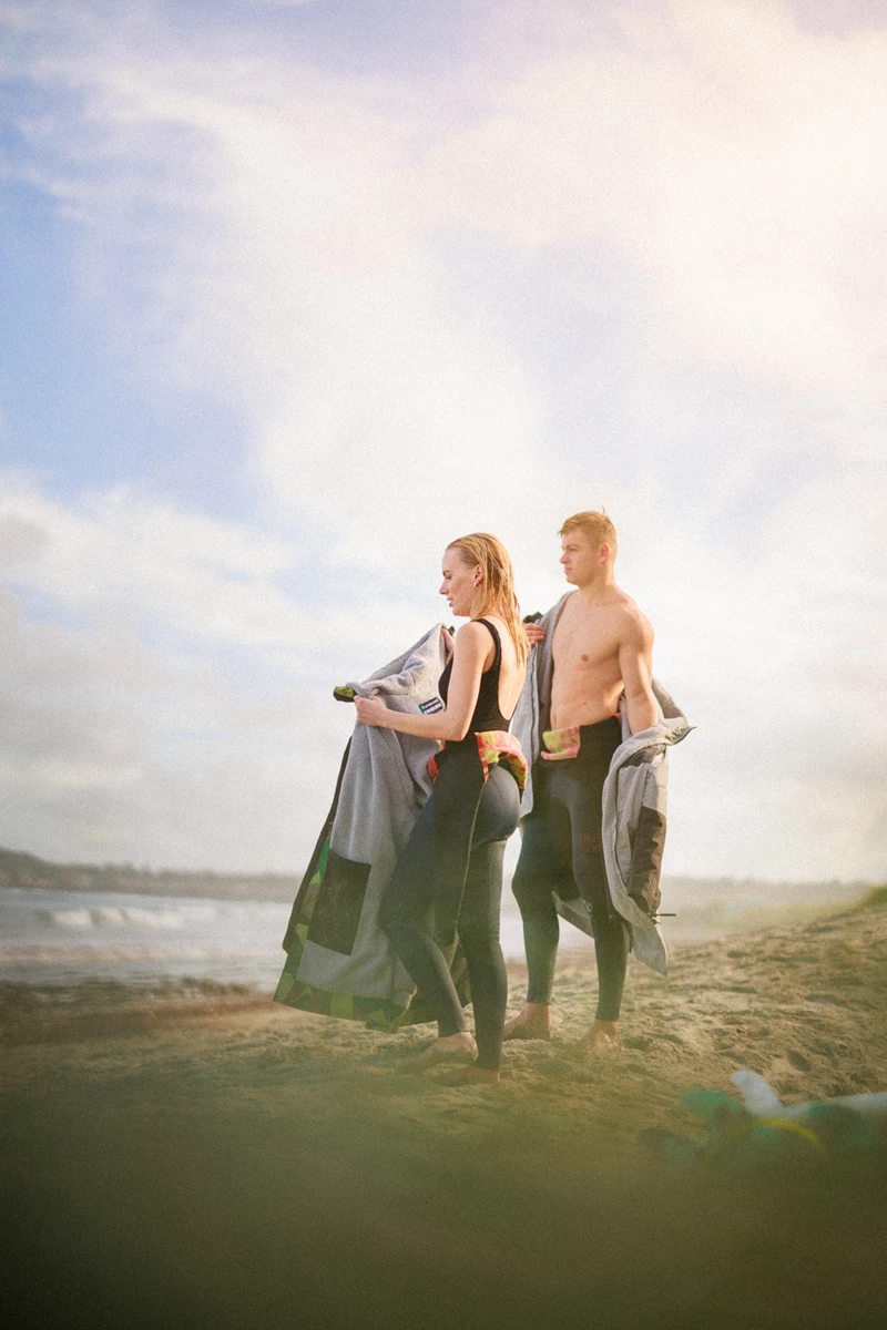 Colour photo of a man and woman standing on a beach