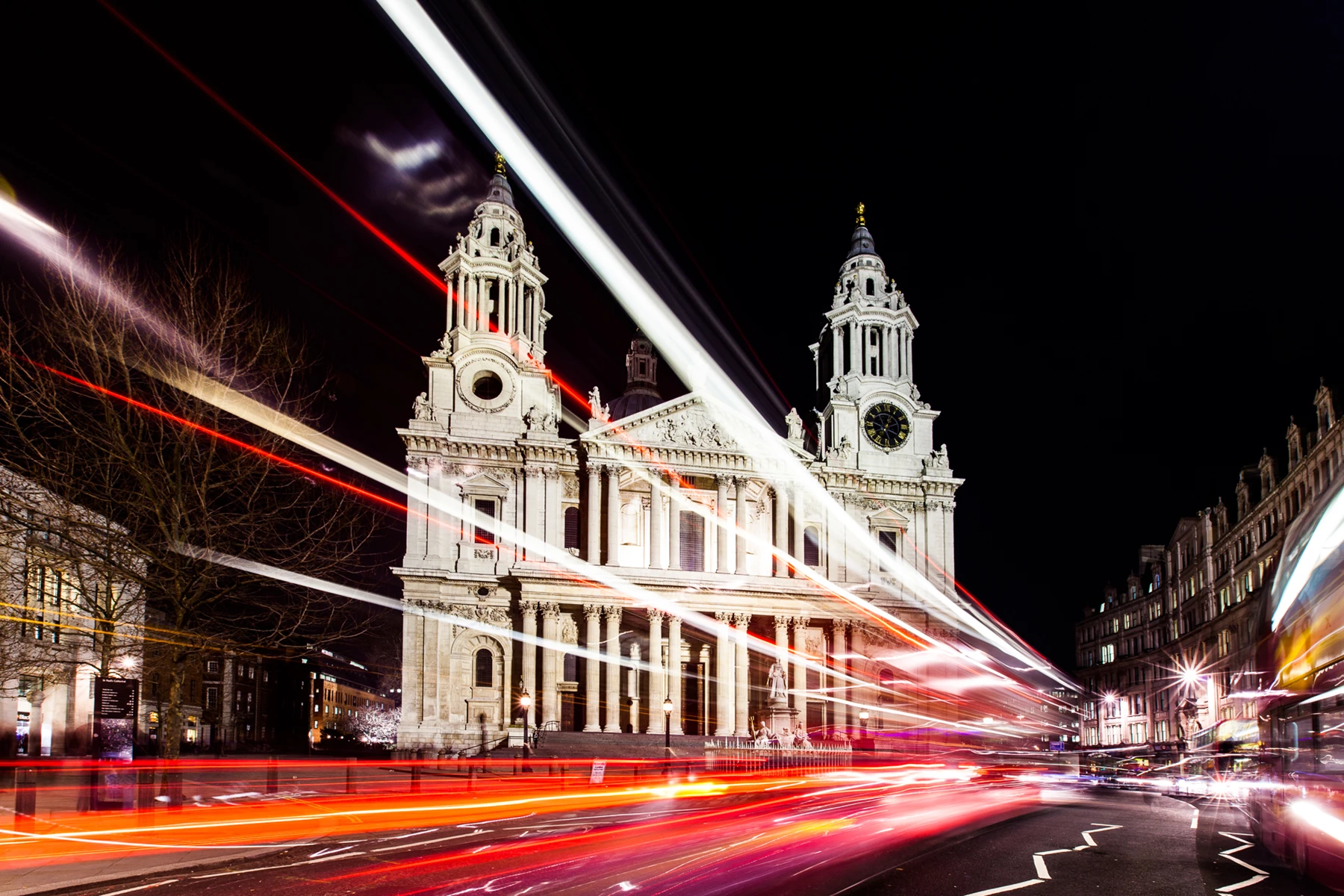Colour photo of a large white building with a clock tower at night